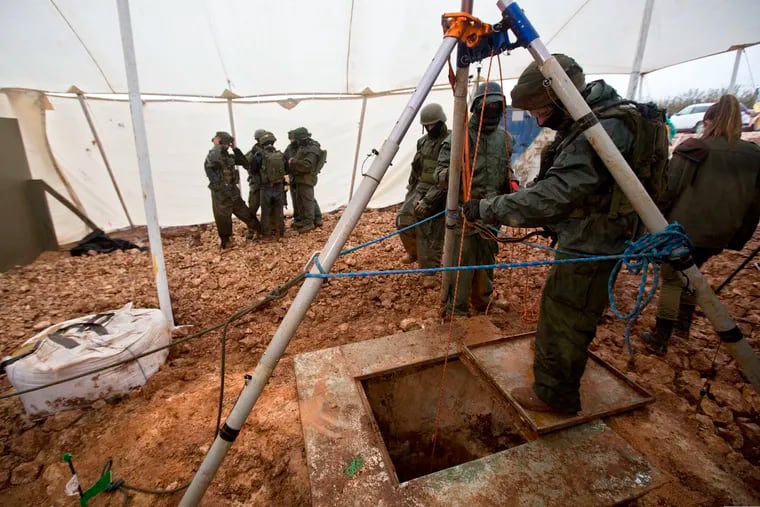 Israeli soldiers stand around the opening of a hole that leads to a tunnel that the army says crosses from Lebanon to Israel, near Metula, Wednesday, Dec. 19, 2018. Israel's prime minister Wednesday called on the U.N. Security Council to condemn "wanton acts of aggression" by the Lebanese militant group Hezbollah, designate it a terrorist organization and heighten sanctions on it over attack tunnels it has dug into Israel. (AP Photo/Sebastian Scheiner)