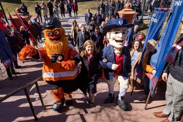 M. Elizabeth Magill the new President of the University of Pennsylvania is escorted into the Fisher Fine Arts Library by Flyers mascot Gritty and the University of Pennsylvania Quaker. She walked the campus along Locust Walk to the Fisher Fine Arts Library after formal approval by the board on Friday, March 4, 2022.