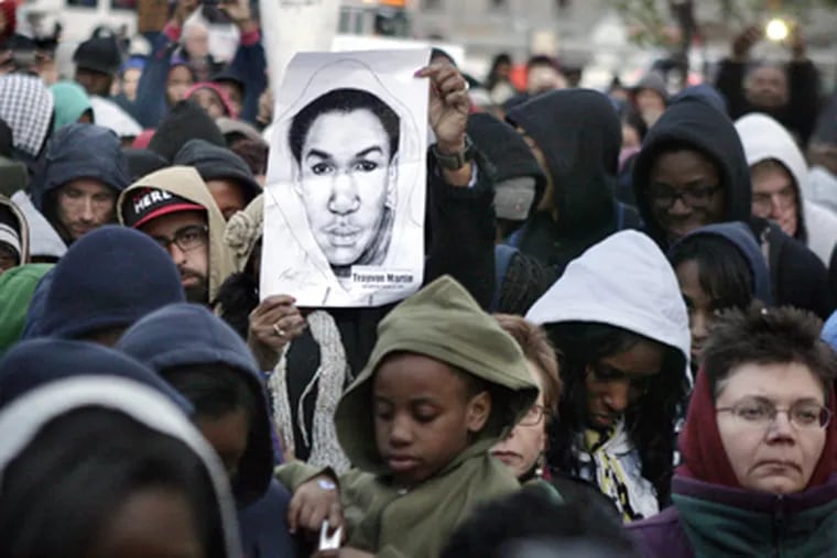 A sketch of Trayvon Martin is held up during the first of three candlelight vigils this week for Trayvon Martin at Love Park in Phila. on Monday. ( Elizabeth Robertson / Staff Photographer )