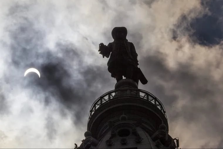 The statue of William Penn atop City Hall is silhouetted by the solar eclipse on Aug. 21.