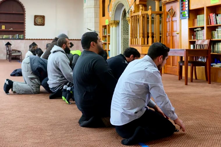 Jalil Navarro, right, and Iman Isa Parada, next to him, take part in the afternoon prayer at Masjid al-Hidaya mosque, in North Philadelphia on April 27, 2019.