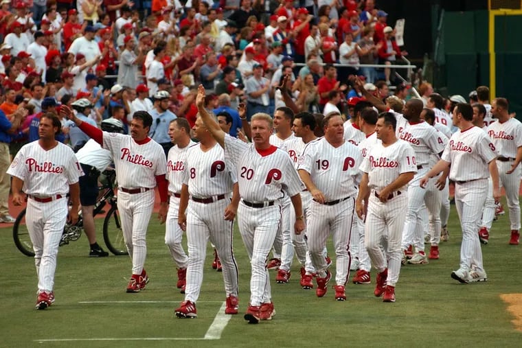 From left, Darren Dalton, John Vukovich, Bob Boone (8), Mike Schmidt, Greg Luzinski, and Larry Bowa join former Phillies players in a final lap around the field at Veterans Stadium after the last game.
