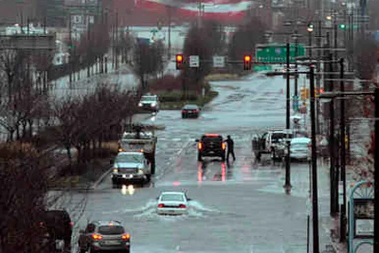 Columbus Boulevard, flooded near Race Street, was among the roads that had to be closed. Montgomery and Bucks Counties were hit hard; about 80,000 Peco Energy Co. customers there had no electricity. (Elizabeth Robertson / Staff)