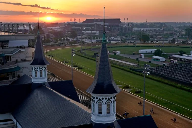 Horses work out as the sun rises at Churchill Downs on Friday. The 147th running of the Kentucky Derby is Saturday.