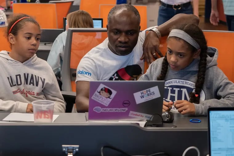 Stephen Osei-Akoto, of Slalom Consultanting, works with two pupils during "Storytelling with Data," a workshop on how to build and structure databases, load data into a modern reporting tool (Tableau), and design & create impactful data visualizations. The event was held in Philadelphia on Sept. 15, 2019.