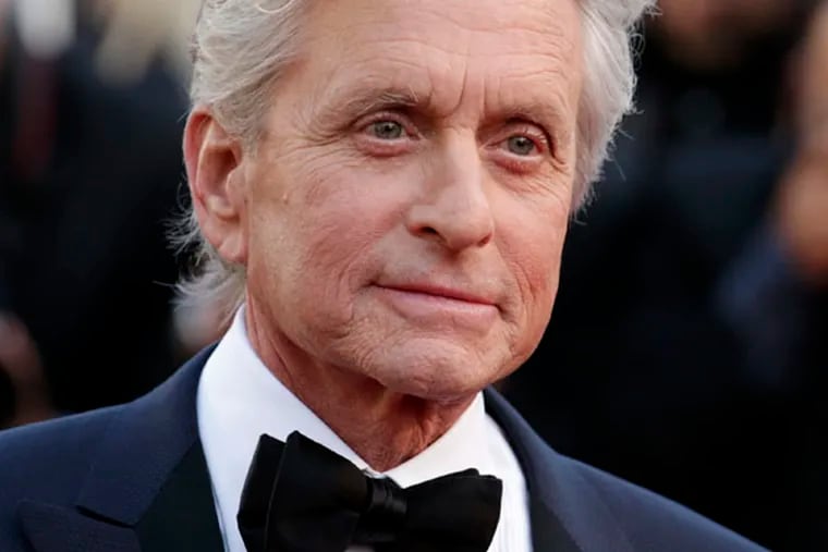 FILE - Actor Michael Douglas poses for photographers as he arrives for the screening of Behind the Candelabra at the 66th international film festival, in Cannes, southern France, in this May 21, 2013 file photo. The Guardian newspaper published an interview Monday June 3, 2013 in which Douglas blamed cunnilingus for the grave malady that was diagnosed in 2010. The newspaper also quoted doctors who were skeptical about his claim. (AP Photo/David Azia, File)