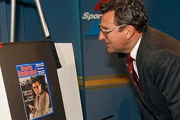 Joe Paterno looks at himself on the cover of Sports Illustrated in December 1986. (G. Paul Burnett/AP)