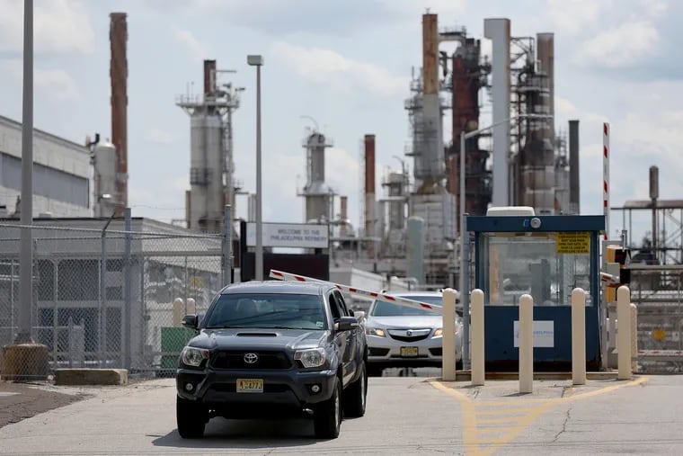 Cars leave the Philadelphia Energy Solutions refinery in South Philadelphia on Tuesday, Aug. 20, 2019. The company announced it is immediately laying off most of its workers at the refinery complex, which closed after a June explosion and fire.