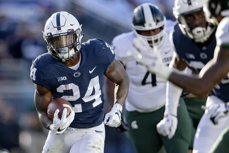 Penn State's Miles Sanders (24) dodges Michigan State defenders en route to a  48-yard touchdown run.