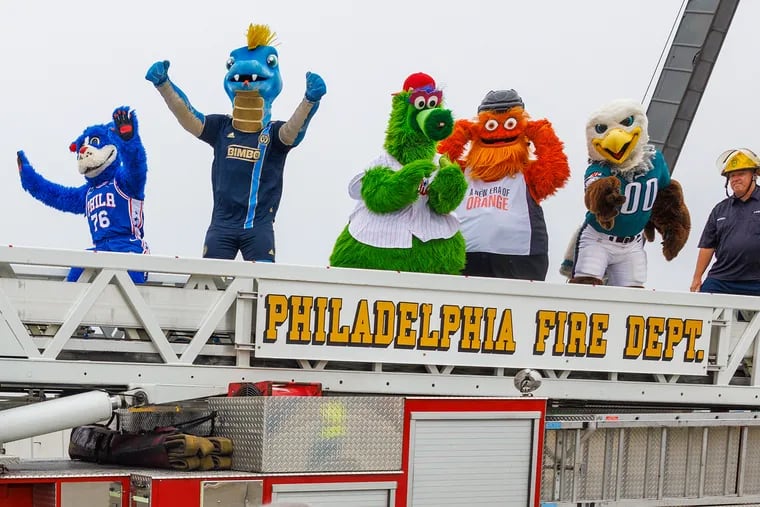 Mascots from professional Philadelphia sports teams cross over the repaired section of I-95 as the highway is reopened Friday.
