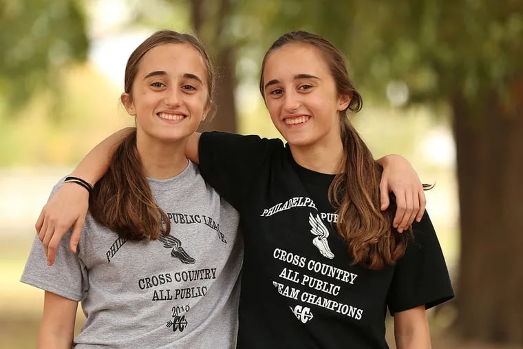 Masterman students Marina, left, and Viki Mancoridis, right, freshman twins who finished first and third in the the Public League cross-country championships last week. They spent the summer running hills in Greece. They will be racing in the District 12 championships on Thursday. They practice along Kelly Drive in Philadelphia, PA on October 27, 2015.