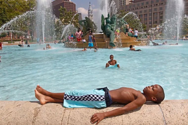Tyshawn Carter, 9, took a break after cooling off in the Swann Memorial Fountain on a hot day last month. Phila.'s average high temperatures were close to normal.