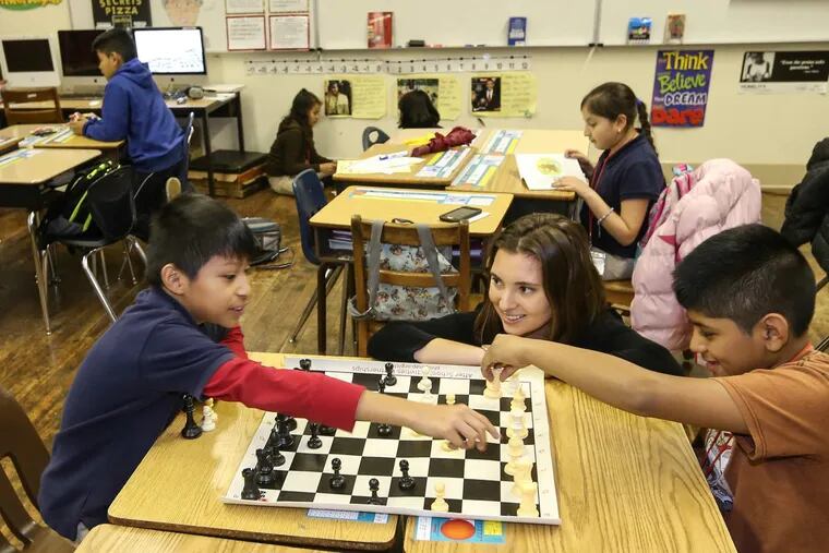 Puentes and program coordinator Alexandra Wolkoff watches fifth graders Miguel Angel del Rosario, left and Miguel Sandoval play chess at the Puentes de Salud, a health clinic for immigrants, which has branched out into the education field with an after-school program