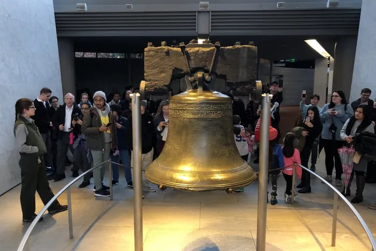 Tourists gather around the Liberty Bell in its pavilion. Does it still represent Philadelphia values?
