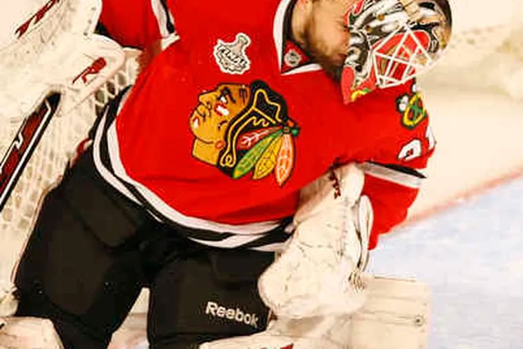 With his mask askew, Chicago's Antti Niemi comes up with a save. He made a key stop on Danny Briere's shot late in the game.