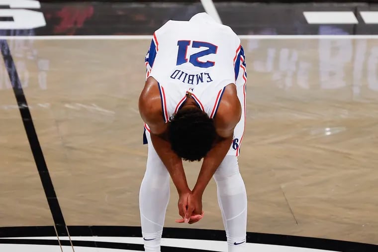 Sixers center Joel Embiid hunches over during the third quarter against the Brooklyn Nets during Game 3 in the first round of the Eastern Conference playoffs on Thursday in New York.