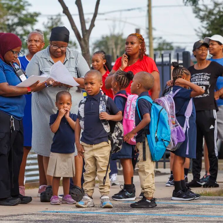 Kimberly Peterson (second from left) gets information about classrooms for her children as she arrives for the first day of classes at Bluford Elementary School in West Philadelphia last year.