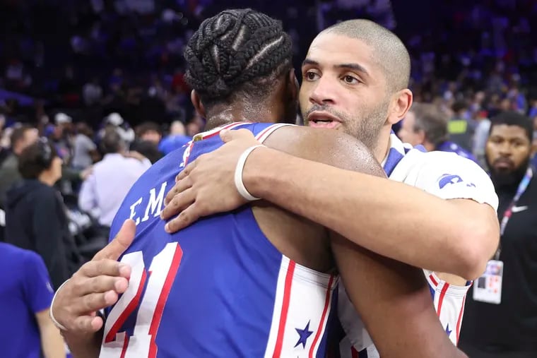 Sixers forward Nico Batum hugs center Joel Embiid after their play-in win over the Miami Heat.
