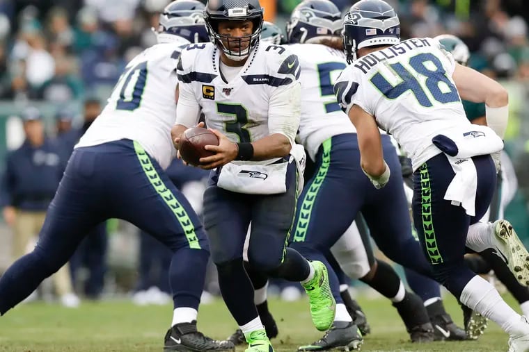 Seattle Seahawks quarterback Russell Wilson holds out the football with teammate tight end Jacob Hollister against the Eagles on Sunday, November 24, 2019 in Philadelphia.