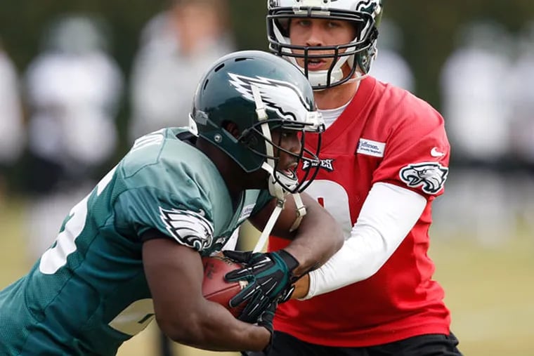 LeSean McCoy (left) takes a hand-off from Nick Foles during Eagles practice at the NovaCare Complex. (David Maialetti/Staff Photographer)