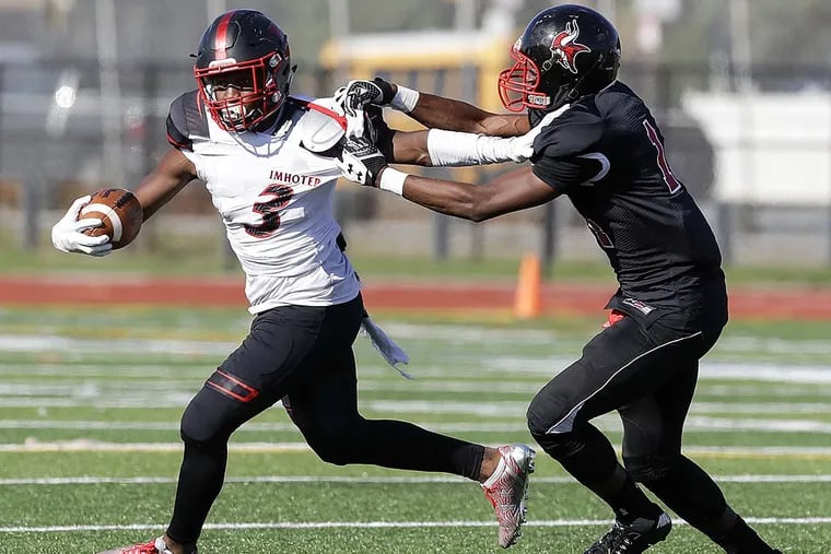 Imhotep’s Isheem Young (left) runs with the football past Northeast’s Deshawn McCarthy.