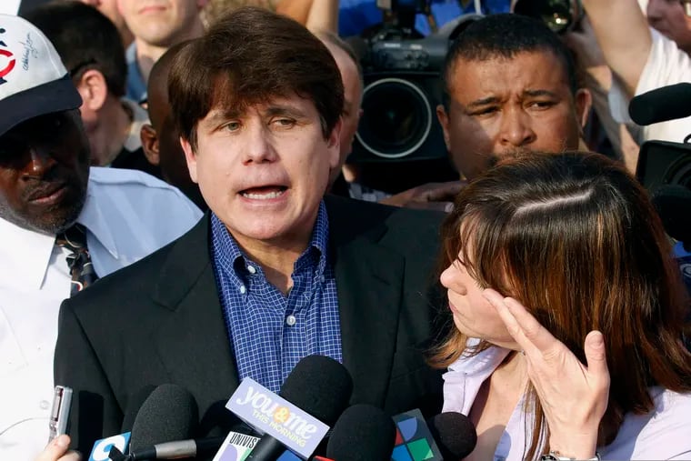 Frmer Illinois Gov. Rod Blagojevich speaks to the media outside his home in Chicago as his wife, Patti, wipes away tears a day before reporting to prison after his conviction on corruption charges in 2012. President Donald Trump is expected to commute the 14-year prison sentence of Blagojevich.
