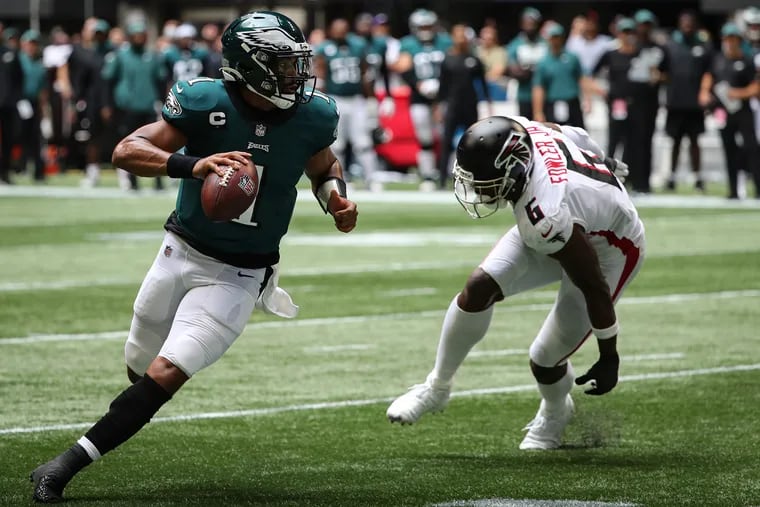 Eagles quarterback Jalen Hurts scrambles away from Atlanta Falcons defensive end Dante Fowler Jr.