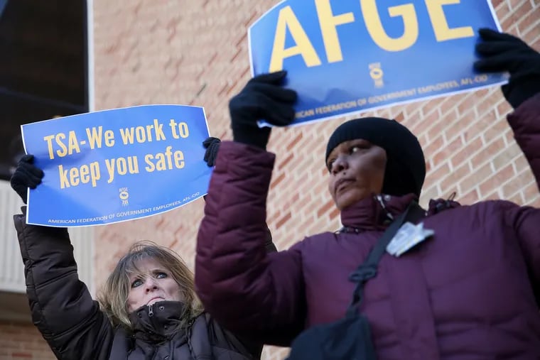 TSA workers Elizabeth Hughes, left, of Williamstown, N.J., and Francesca Saoudi, of Sharon Hill, Pa., hold signs during a rally against the government shutdown outside Philadelphia International Airport in Philadelphia on Friday, Jan. 25, 2019. Local members of Congress and furloughed government employees called for an end to the shutdown as workers missed another paycheck Friday.