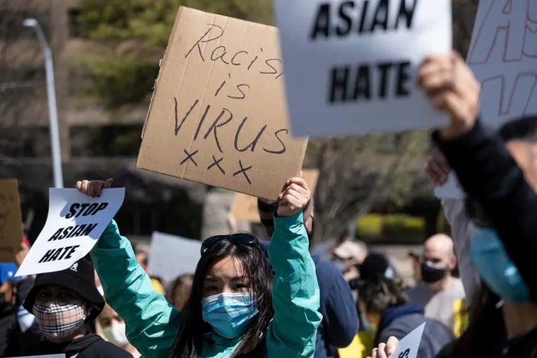 Sabrina Bijeaux holds signs while participating in a “Stop Asian Hate” rally outside the Georgia State Capitol in Atlanta in March.