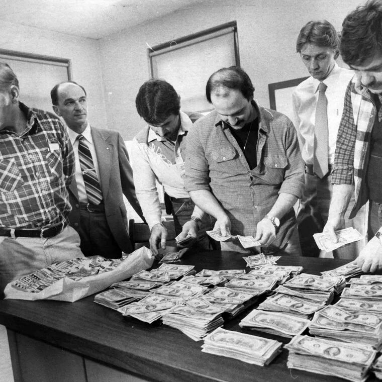 From left: Detective Frances Bresch, Purolator employee Jack Toward, Detectives Martin Mikstas and Pat Laurenzi, Captain Robert Eichler, and Detective James Ptocnaic count money recovered from the Joey Coyle robbery during a February 1981 news conference. File Photograph