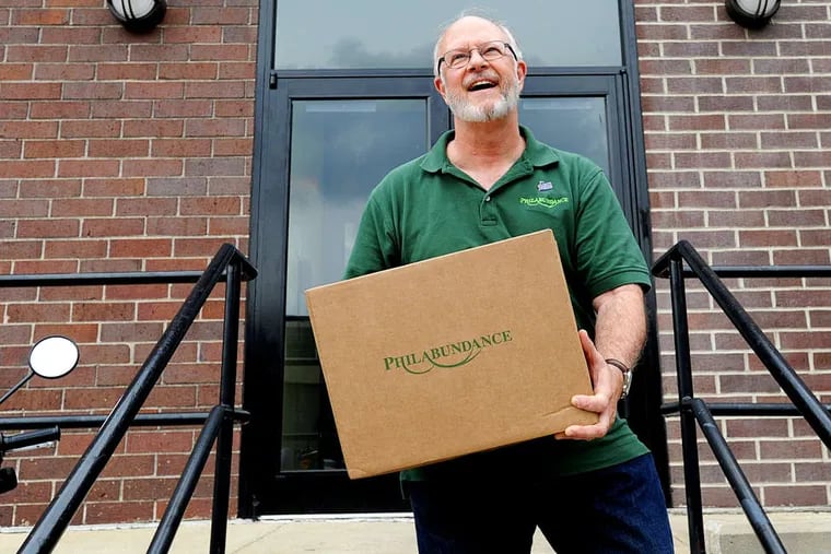 Bill Clark carrying a box in 2011 filled with food for a disabled senior living on $14,000 or less. Clark is ending his controversial tenure with Philabundance.