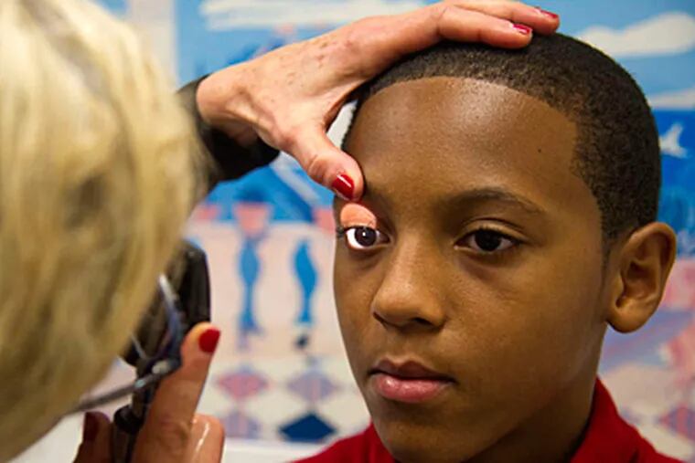 Jordan Goins,12, is examined by pediatrician Cheryl Hausman.When he had symptoms after hitting his head, his mother made him undergo &quot;cognitive rest.&quot; (CLEM MURRAY / Staff Photographer)