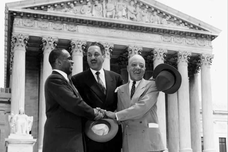 George E.C. Hayes, Thurgood Marshall and James M. Nabrit join hands as they pose outside the Supreme Court in Washington on May 17, 1954 — the day the court ruled in Brown v. Board of Education that "separate but equal" education was unconstitutional.