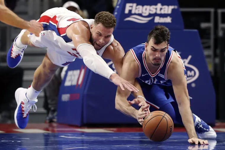 Pistons forward Blake Griffin, left, and 76ers forward Dario Saric reach for a loose ball during the second half.