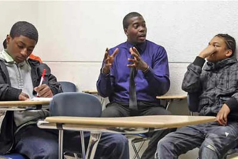 Jay Barnes (center), of the Don't Fall Down in the Hood program, explains job-interview skills to clients Andre Chambers (right) and Keith Richardson (Steven M. Falk / Staff)