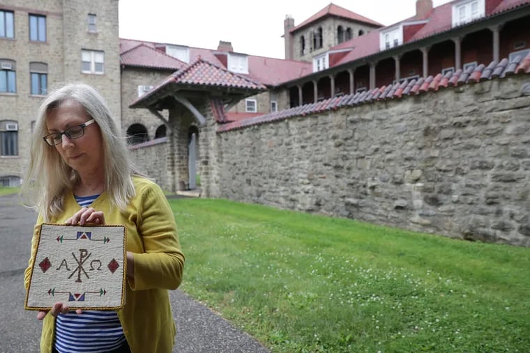 Auctioneer Cindy Stephenson holds one of the items available for auction as she prepares for the event at the former location of the Shrine of Saint Katharine Drexel in Bensalem, PA on May 28, 2019.