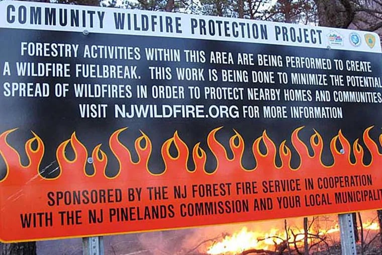 A sign from 2012 describes a prescribed fire in the Pinelands in Lacey Township. Environmentalists say the approach is flawed, but advocates say some efforts must be taken to aid the state's forests. (AP photo)
