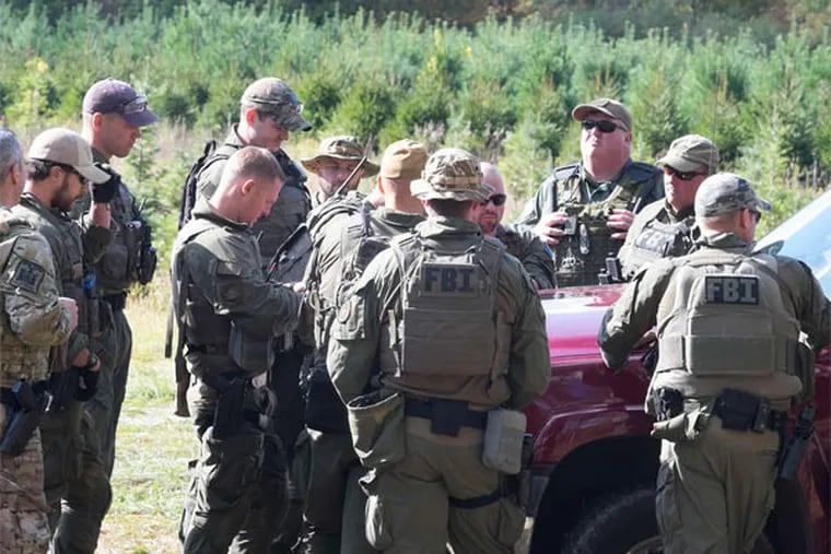 FBI agents searching for Eric Frein gather for a briefing on a field near a tree nursery along Route 447 in Canadensis, Pa. (Ed Hille / Staff Photographer)