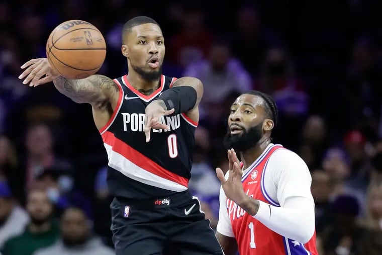 Portland Trail Blazers guard Damian Lillard passes the basketball past Sixers center Andre Drummond during the first quarter on Monday, November 1, 2021 in Philadelphia.