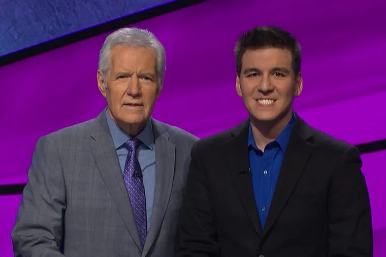 “Jeopardy!” host Alex Trebek (left) stands beside current champion James Holzhauer.