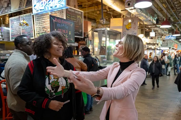 Celine McGee, right, pays a compliment to Julie Jones, a Chicago attorney, at Reading Terminal Market. When she's not working, McGee spends time walking around town, handing out compliments to strangers.