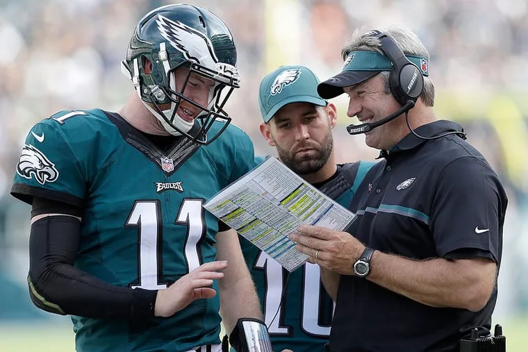 Eagles head coach Doug Pederson has a laugh with quarterback Carson Wentz.