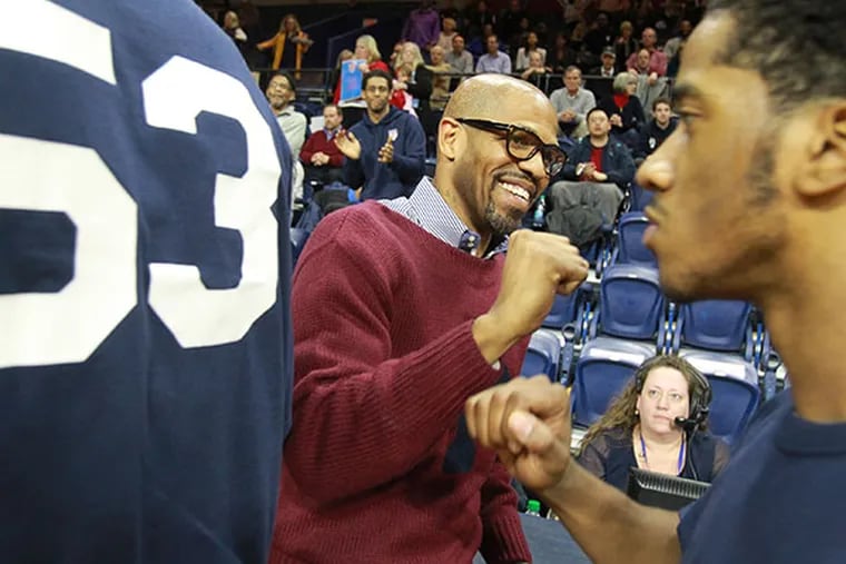 Penn head coach Jerome Allen pounds fists with his players prior to their game against Princeton on March 10, 2015. (Charles Fox/Staff Photographer)