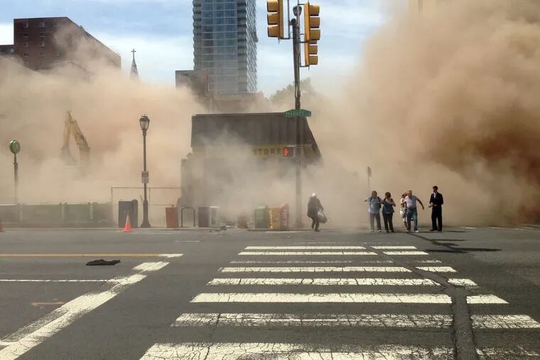 A dust cloud rises as people flee the June 5 building collapse at 22d and Market.