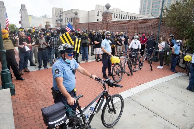 Police block the media and counterprotesters to allow members of the Proud Boys to go back to their cars at the end of their march from Penn’s Landing to City Hall and back on Saturday.