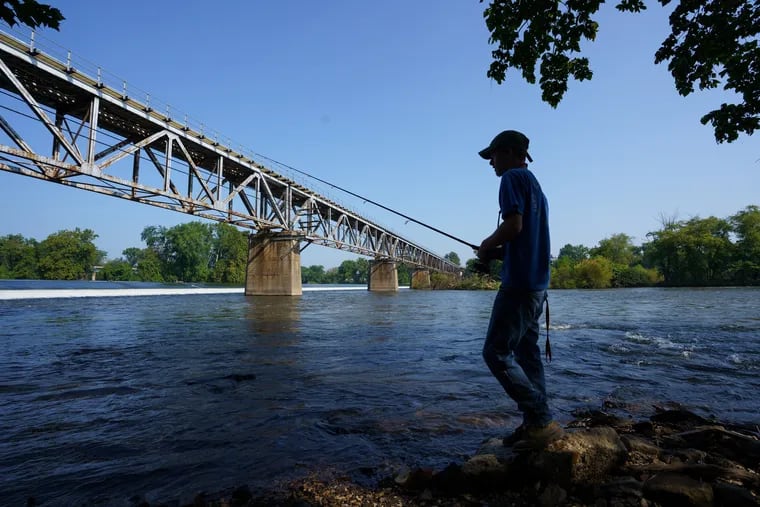 Kevin Rodenbaugh, 20, of King of Prussia, who recently caught a 45-inch Muskie in the Schuylkill, shown here fishing off the banks of the Schuykill River, near Bridgeton, PA, Tuesday, August 28, 2018. JESSICA GRIFFIN / Staff Photographer