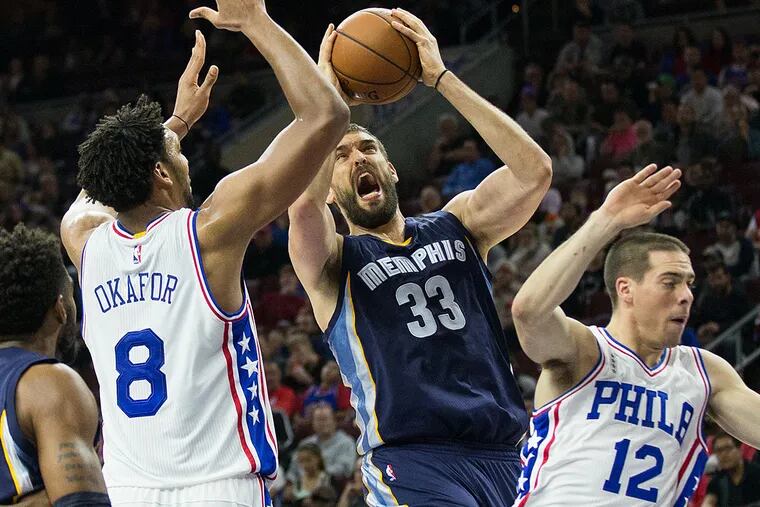 Memphis Grizzlies center Marc Gasol (33) attempts a shot between Philadelphia 76ers center Jahlil Okafor (8) and guard T.J. McConnell (12) during the second quarter at Wells Fargo Center.