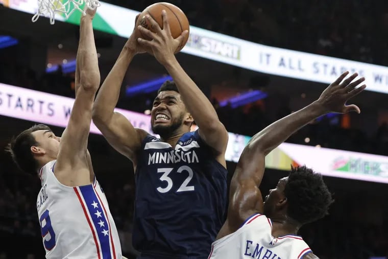 Sixers forward Dario Saric (left) and center Joel Embiid (right) contest Timberwolves’ big man Karl-Anthony Towns during the Sixers’ win on Saturday.