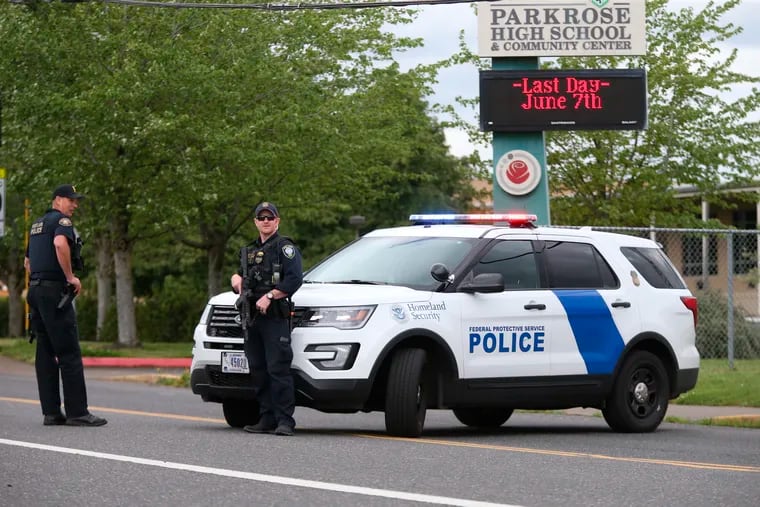 Police are positioned outside Parkrose High School during a lockdown after a man armed with a gun was wrestled to the ground by a staff member, Friday, May 17, 2019, in Portland, Ore. (Dave Killen / The Oregonian via AP)