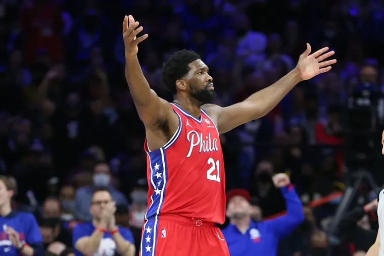 Joel Embiid of the Sixers raises his arma to the crowd late in their victory over the Warriors at the Wells Fargo Center on Dec. 11, 2021.